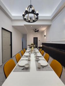 a long table in a room with chairs and a chandelier at LYL 108 Private Pool Villa in Ipoh +123 photos
