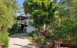 Coastal Canopy - your doorstep to Mount Coolum في كولوم: بيت ابيض فيه اشجار وممر