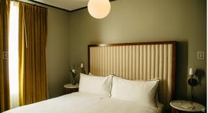 ein Schlafzimmer mit einem großen Bett und weißen Kissen in der Unterkunft Hotel Emeline in Charleston