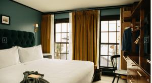 ein Hotelzimmer mit einem Bett und einem großen Fenster in der Unterkunft Hotel Emeline in Charleston