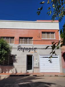 un edificio in mattoni rossi con garage bianco di Refugio del Turista a Tupiza