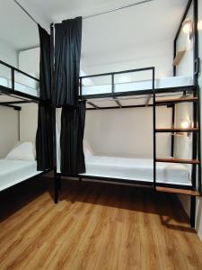 a room with two bunk beds and a wooden floor at Puy-An, A Nomad Hostel in Moalboal