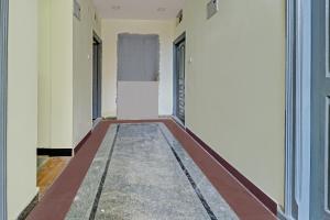 UpalHotel O Abhi's R Square的一座建筑物的走廊，墙壁是白色的，地板是红色的。