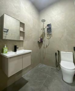 un bagno con un water, un lavandino e uno specchio di Cozy Corner House, Bandar Utama a Gua Musang Altre 7 foto