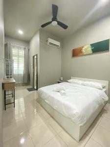 una camera da letto bianca con un letto e un ventilatore a soffitto di Cozy Corner House, Bandar Utama a Gua Musang