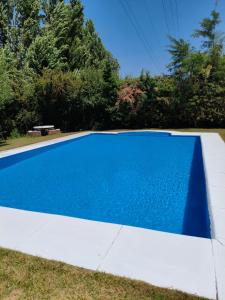 una piscina blu in un cortile con alberi di Posada Finca La Soledad a Las Compuertas