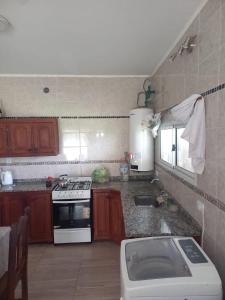 a small kitchen with a stove and a sink at Descanso LA MARTA in Pueblo Esther +2 photos