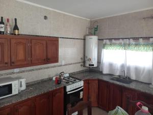 a kitchen with wooden cabinets and a stove top oven at Descanso LA MARTA in Pueblo Esther