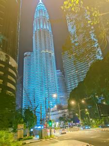 a tall building with lights on it in a city at Sky Suite KLCC Apartment klcc in Gua Sai