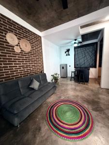 a living room with a couch and a brick wall at Casa Xolo Coco in Brisas de Zicatela