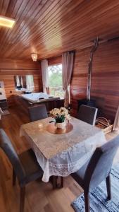 a dining room with a white table and chairs at Cabana Alpen Ville 01 - Rural com Banheira de Hidromassagem in Bom Jardim da Serra