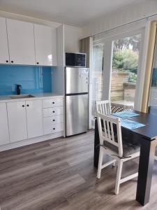Kookaburra Retreat - Apartment في بكنهام: مطبخ مع طاولة وكرسي وثلاجة