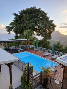 a swimming pool on a deck with a mountain in the background at Les hauts du fromager in Le Diamant