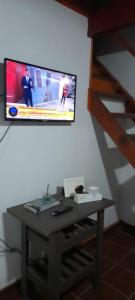 una camera con tavolo e TV a parete di Ensueños del mar a Las Toninas 1 altra foto