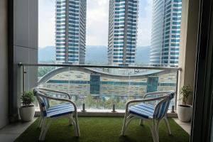 two chairs on a balcony with a view of tall buildings at Montressa Highrise Executive Serviced Apartments Opposite Centaurus Mall Islamabad in Islamabad