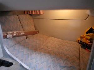 Sunseeker ZERO 6 - a Sunseeker San Remo 33 في Saint Peter Port: سرير صغير في غرفة صغيرة