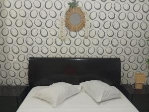 普拉亚Four Palms Boutique Hotel的一间卧室配有一张带两个枕头和镜子的床 更多13张照片