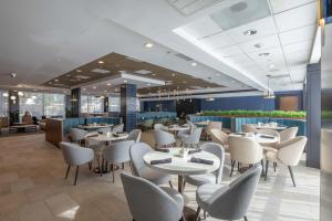 ヒューストンにあるCrowne Plaza Houston Galleria Area by IHGの部屋にテーブルと椅子があるレストラン