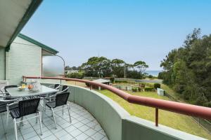 a patio with a table and chairs on a balcony at Fathoms 13 Mollymook Beach in Mollymook