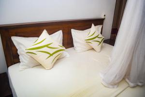 un lit avec quatre oreillers dessus dans l'établissement Sunworld Villa, à Unawatuna