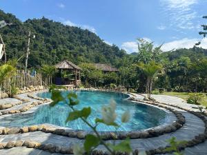 a swimming pool in a resort with mountains in the background at Ba be farmstay in Ba Be18