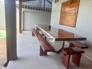 a wooden table and benches in a room at Cantinho Aconchegante in Macapá