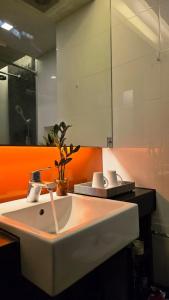 Beautiful Pool View Studio in Kata في شاطئ كاتا: حمام مع حوض أبيض وجدار برتقالي +7 صور