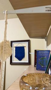 une table avec un tableau et un bol en verre à côté d'un livre dans l'établissement Hostel Ninho das Harpias, à Divino de São Lourenço