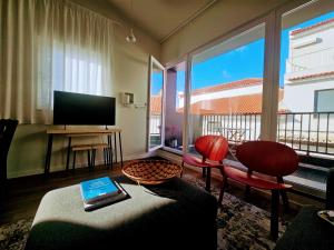 a living room with a couch and a television at Apartamento Sonho Sky in Ponta Delgada