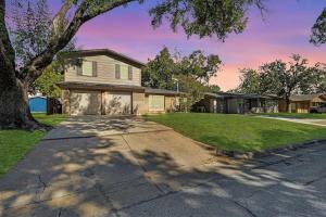 a house with a tree and a driveway at 5 min to AT&T Stadium, Game Room, Huge Yard in Arlington