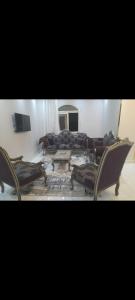 ein Wohnzimmer mit Sofa und Tisch in der Unterkunft مكان هادي وراقي للاسترخاء in Kafr Mas‘ūd