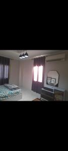 ein Schlafzimmer mit einem Bett, einem Schreibtisch und einem Spiegel in der Unterkunft مكان هادي وراقي للاسترخاء in Kafr Mas‘ūd