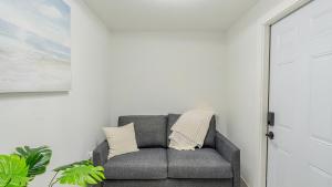 迈尔斯堡Florida Paradyse ll 5 min downtown Cozy Modern的白色墙壁的房间里一张灰色的沙发