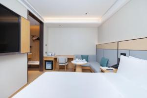 a living room with a couch and a table at JI Hotel Shenzhen Huaqiang North Huaqiang Road Subway Station in Shenzhen