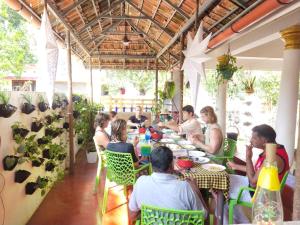 un grupo de personas sentadas en mesas en un restaurante en Marari Beach Cleetus Homestay, en Alleppey