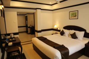 Una habitación de hotel con una cama grande y una mesa. en Hotel Aroor RESIDENCY, en Jāmb