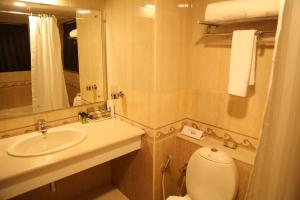 Un baño con lavabo, inodoro y espejo. en Hotel Aroor RESIDENCY, en Jāmb