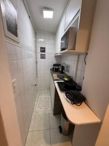 eine kleine Küche mit einem Waschbecken und einer Dusche in der Unterkunft Studio lindo e completo no Centro RJ in Rio de Janeiro