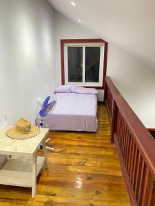 a bedroom with a bed and a table and a window at Onat Roatan Casa in West End