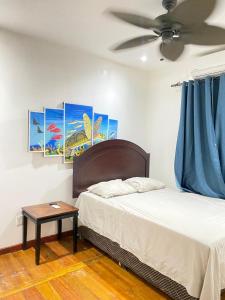 a bedroom with a bed and a ceiling fan at Onat Roatan Casa in West End