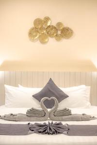a bed with two swans made out of towels at Treerat Bangtao House in Ban Hua Phrong
