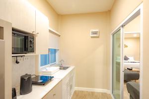 a bathroom with a sink and a mirror at Treerat Bangtao House in Ban Hua Phrong