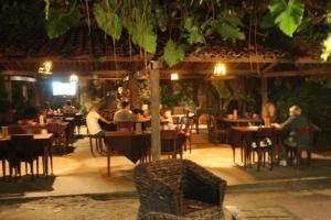 a group of people sitting at tables in a restaurant at Sonia Flats 211 - Apart Hotel Pipa's Bay in Pipa