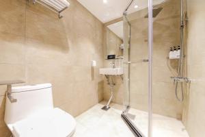 Un baño con ducha, inodoro y lavabo. en Winners Hotel, en Gangneung