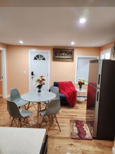 Una sala de estar con una mesa y un refrigerador. en Unique Monthly Rentals For Professionals, en Baychester