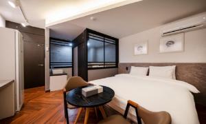 a bedroom with a bed and a table with a table at Iksan 4 Seasons Hotel in Iksan