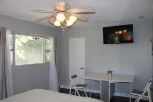 里弗赛德Private Room with Laundry and Pool access的一间卧室配有一张床、一张桌子和吊扇