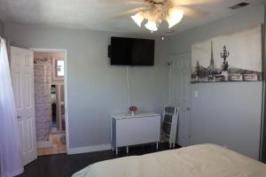 里弗赛德Private Room with Laundry and Pool access的一间卧室，墙上有一张床和一台电视