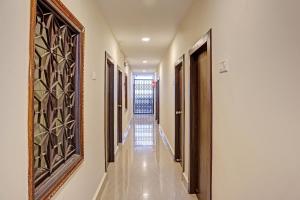 a hallway with doors and a mirror on the wall at Hotel O Ramya Inn in Warangal