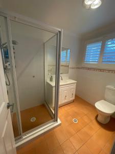 a bathroom with a shower and a toilet and a sink at Coastal play and stay - walk to beach and park in Toowoon Bay +12 photos